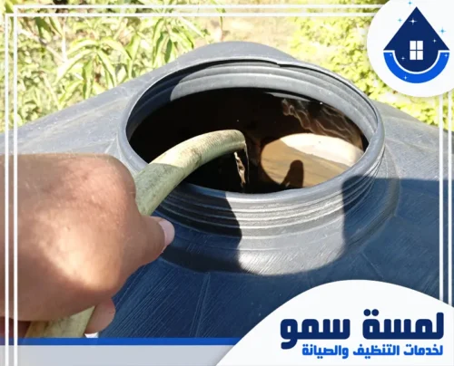 تنظيف خزانات بلاستيك بالرياض 0554516792 لمسة سمو خرطوم مياه يقوم بملء خزان مياه بلاستيكي أسود اللون، ضمن خدمات شركة لمسة سمو