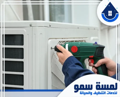 تصليح مكيفات بجدة 0554516792 لمسة سمو فني يستخدم مثقاباً كهربائياً (دريل) لتثبيت أو صيانة الوحدة الخارجية للتكييف، مما يعكس مهارة شركة لمسة سمو