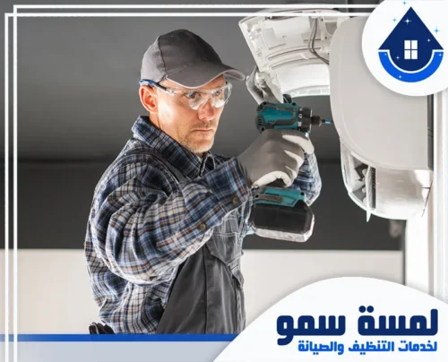 صيانة مكيفات بجدة 0554516792 لمسة سمو فني متخصص يرتدي نظارات واقية يستخدم مثقاباً كهربائياً لتثبيت أو صيانة وحدة تكييف داخلية