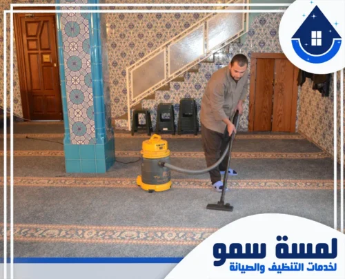 غسيل موكيت المساجد بجدة 0554516792 لمسة سمو خدمات شركة تنظيف مساجد بجدة المتميزة، حيث يظهر فني متخصص من فريق لمسة سمو وهو يستخدم مكنسة كهربائية صناعية قوية لشفط الأتربة