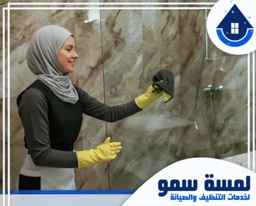 افضل عاملات تنظيف بالساعة بجدة 0543207472 لمسة سمو الصورة عملية تلميع الأسطح الزجاجية في دورات المياه، حيث تظهر الموظفة وهي تستخدم أدوات مسح دقيقة لإزالة البقع.